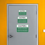 Classic Framed Plus Caution Testing In Progress Wall or Door Sign | Bilingual Spanish and English Workplace Safety Signage