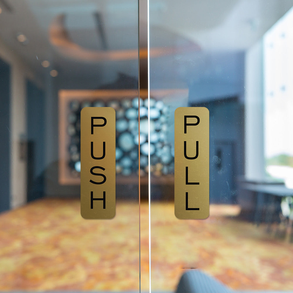 Gold push and pull signs on glass entry doors
